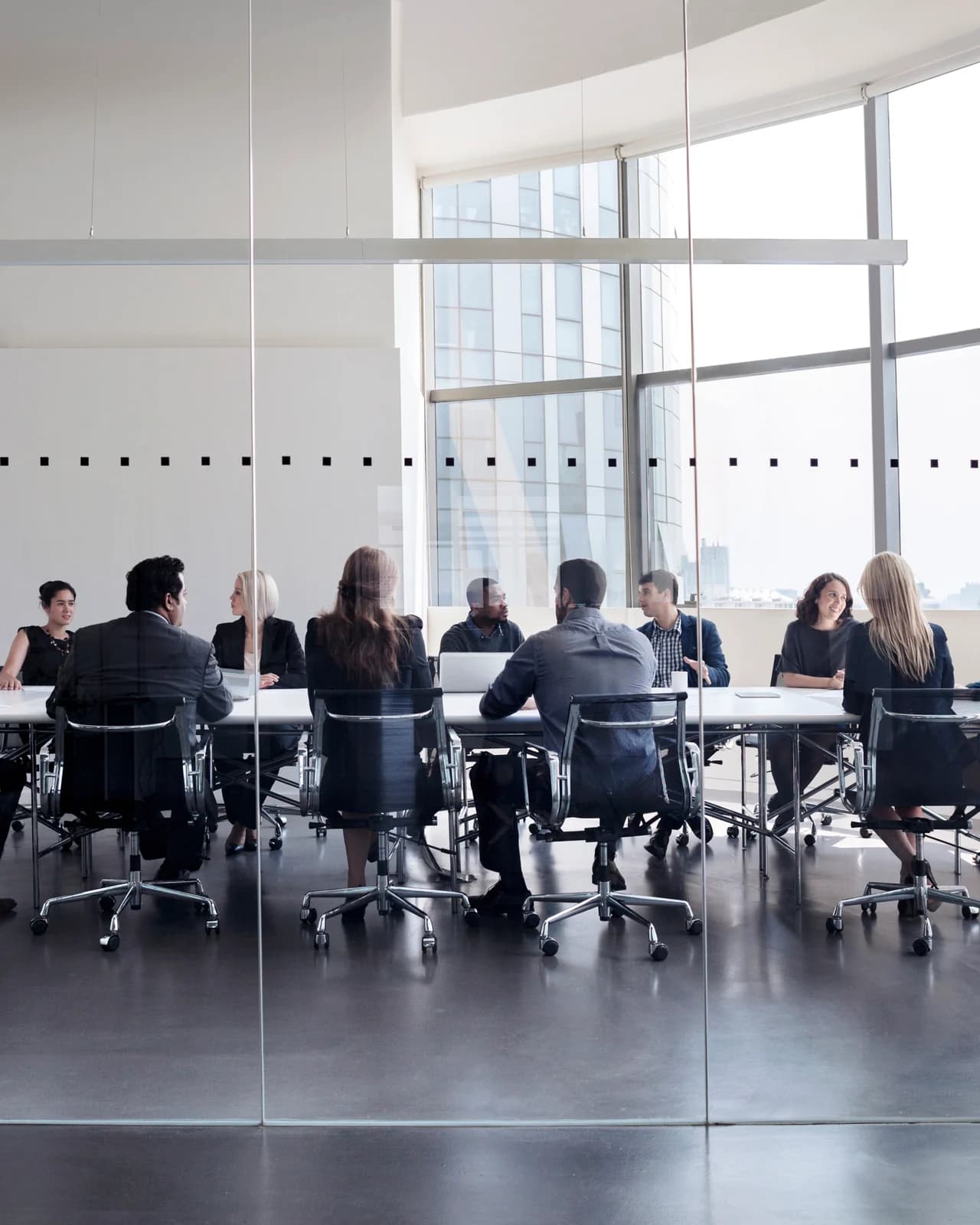 Colleagues meeting in a glass-walled conference room